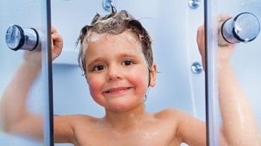 smiling boy standing between new shower doors