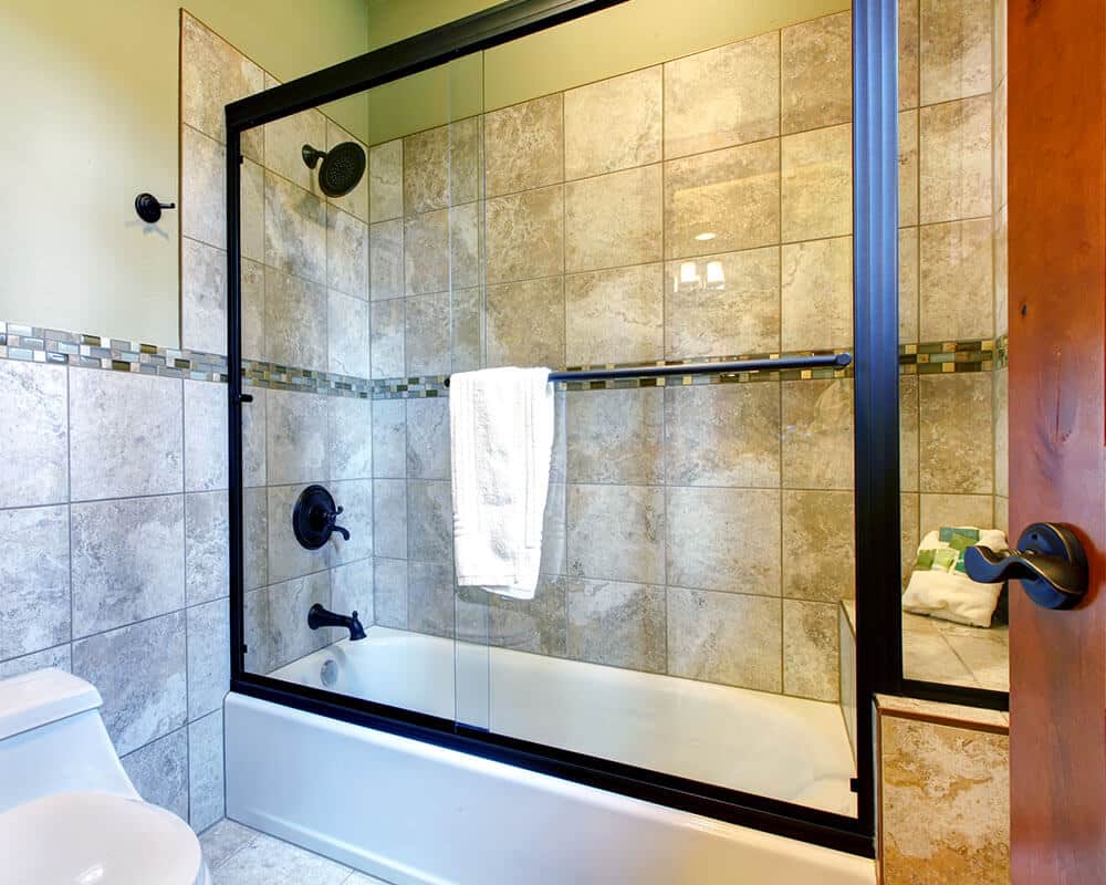 sliding bathtub shower door with dark brass frame