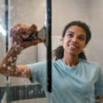 woman cleaning glass shower doors