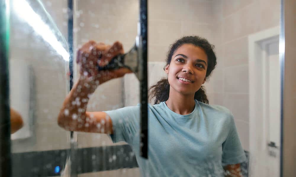 woman cleaning glass shower doors